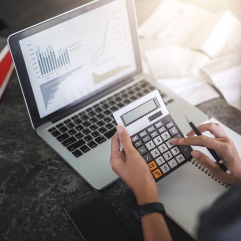 person on laptop and calculator