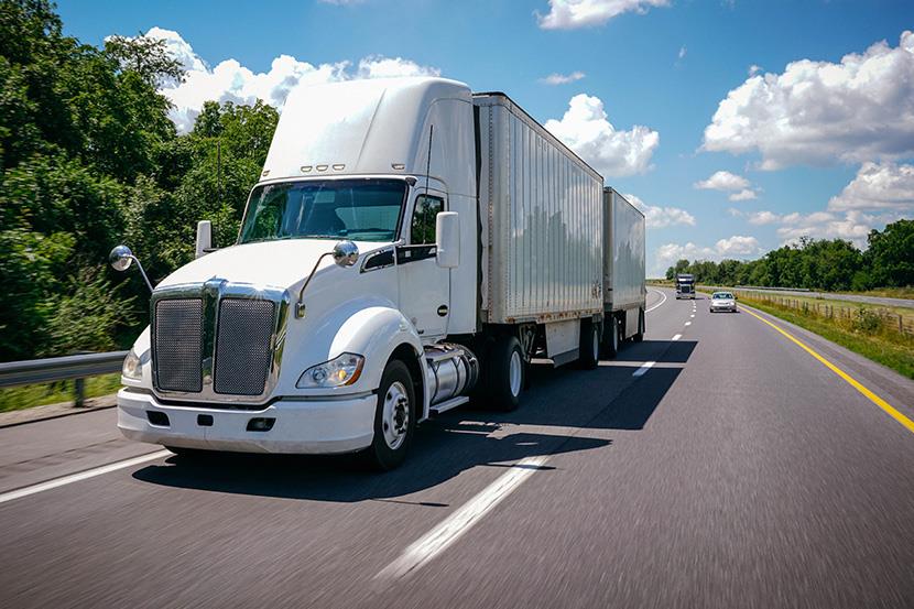 cwhite tractor trailer semi truck double trailer on the road