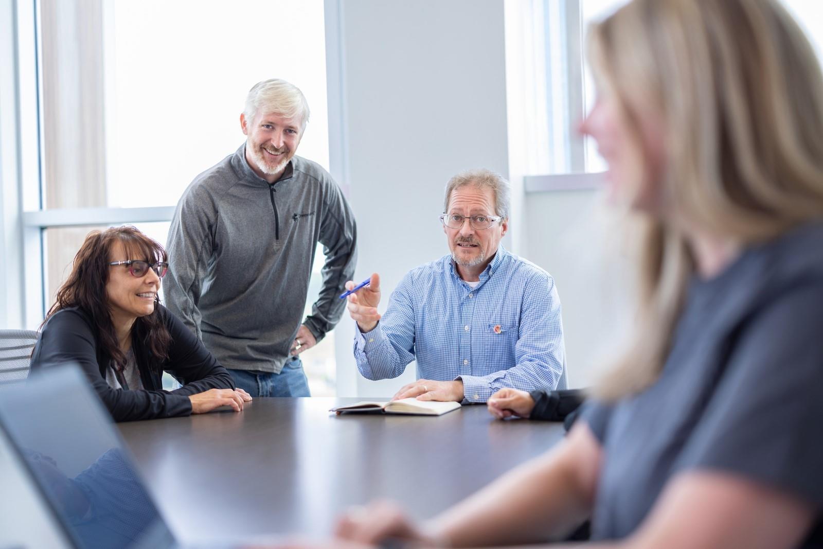 4 people working together in an office