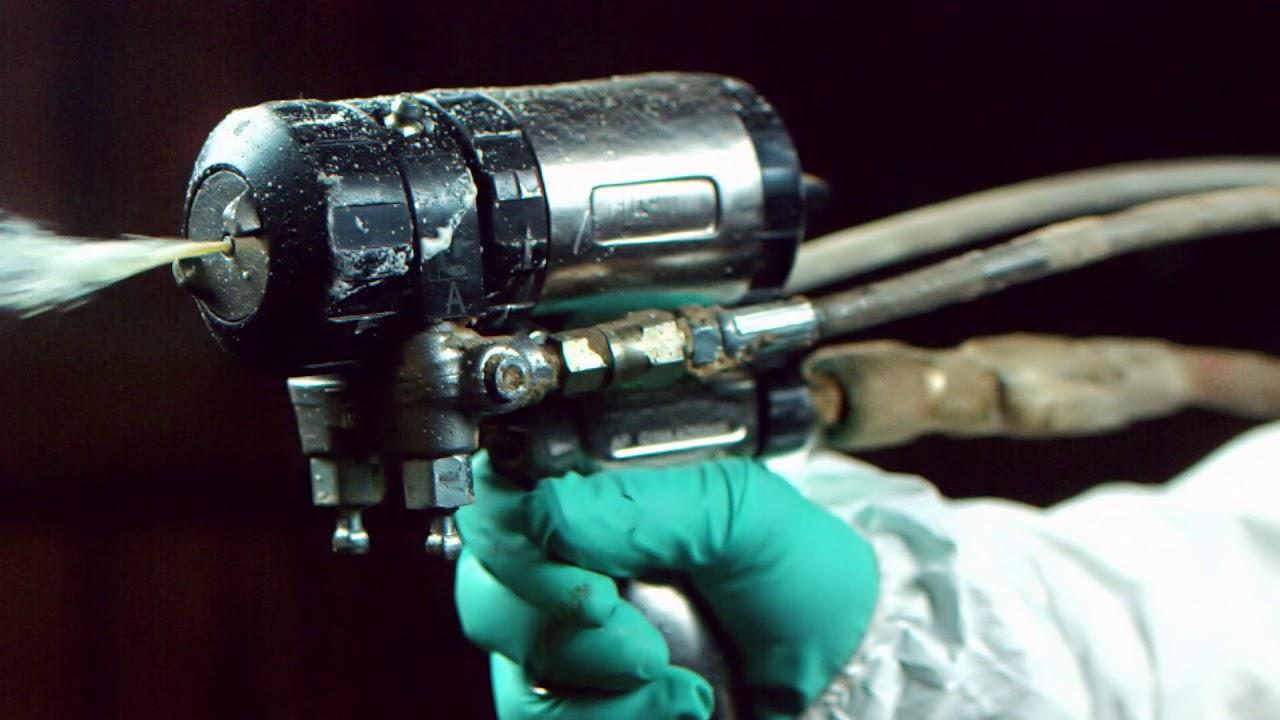 Spray foam insulation being sprayed from a gun